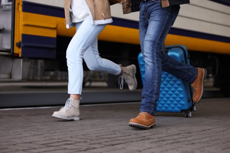 Paar rennt mit Koffern am Bahnsteig